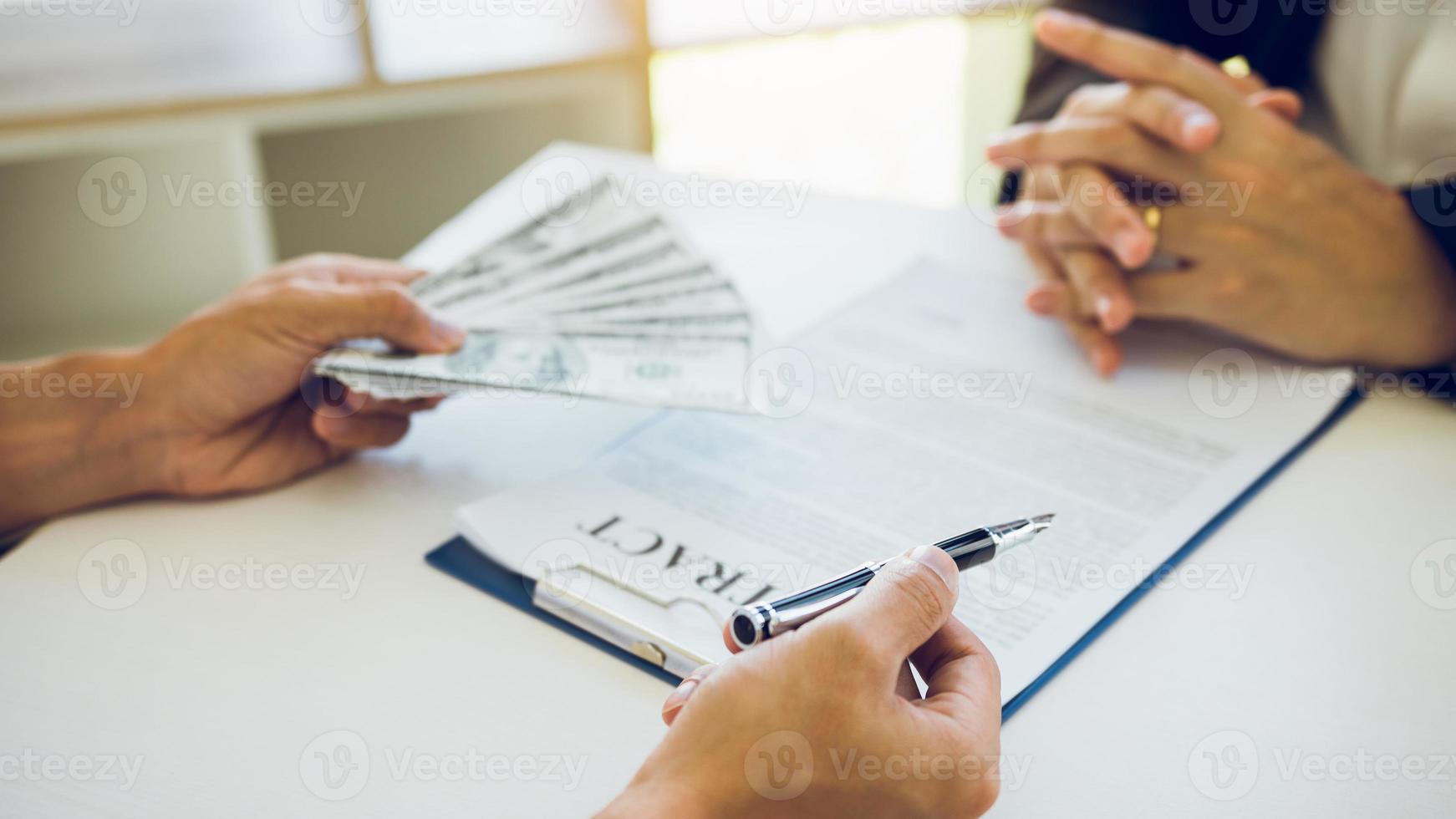 Partner has made a fraud in the contract of sale and being handed a cash and pen to the businessman signing the contract corruption bribery concept. photo