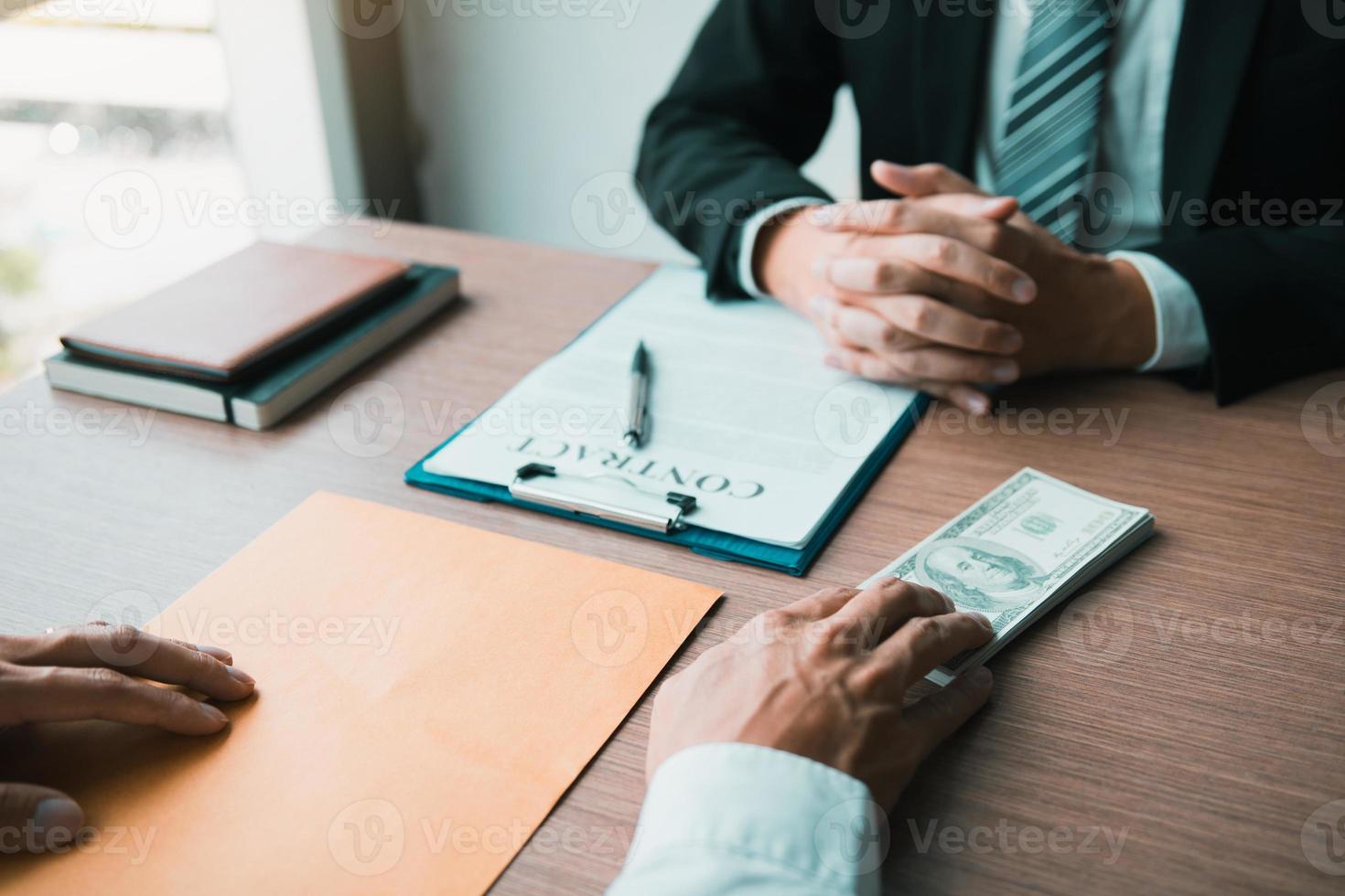 Partner has made a fraud in the contract of sale and being handed a cash and pen to the businessman signing the contract corruption bribery concept. photo