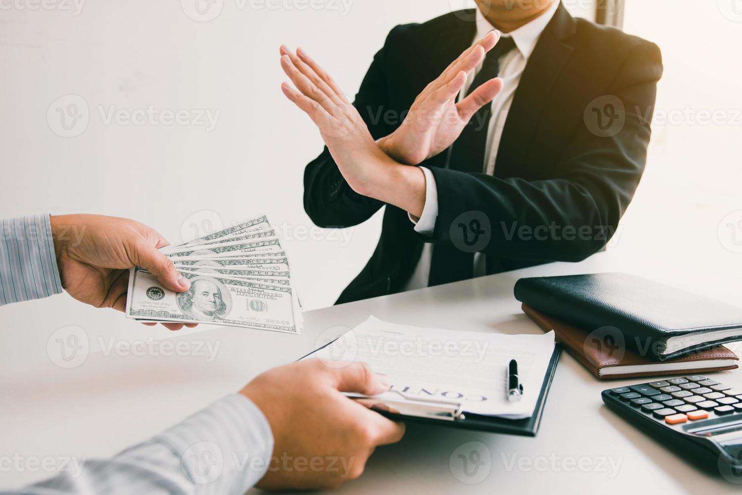 Business person refusing bribe given money by partner with anti bribery corruption concept. photo