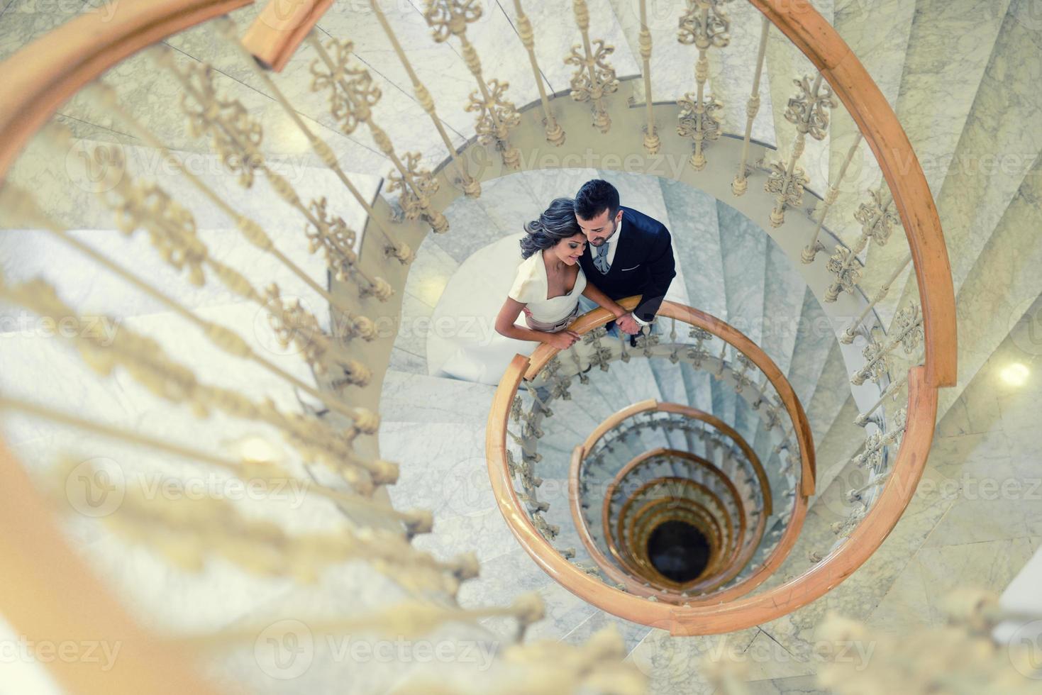pareja de recién casados en una escalera de caracol foto