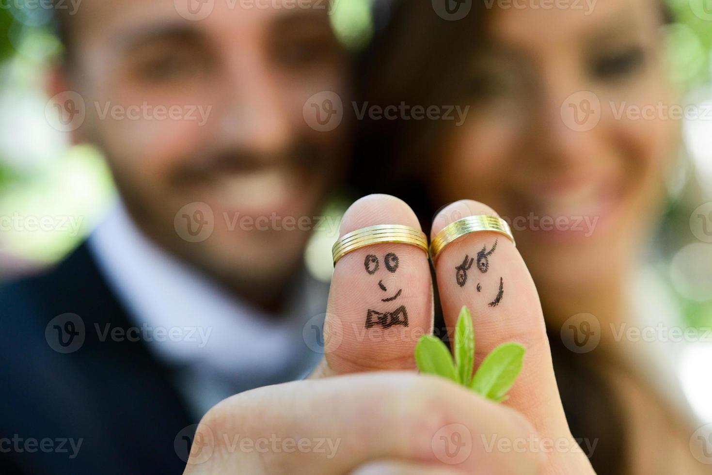 wedding rings on their fingers painted with the bride and groom photo
