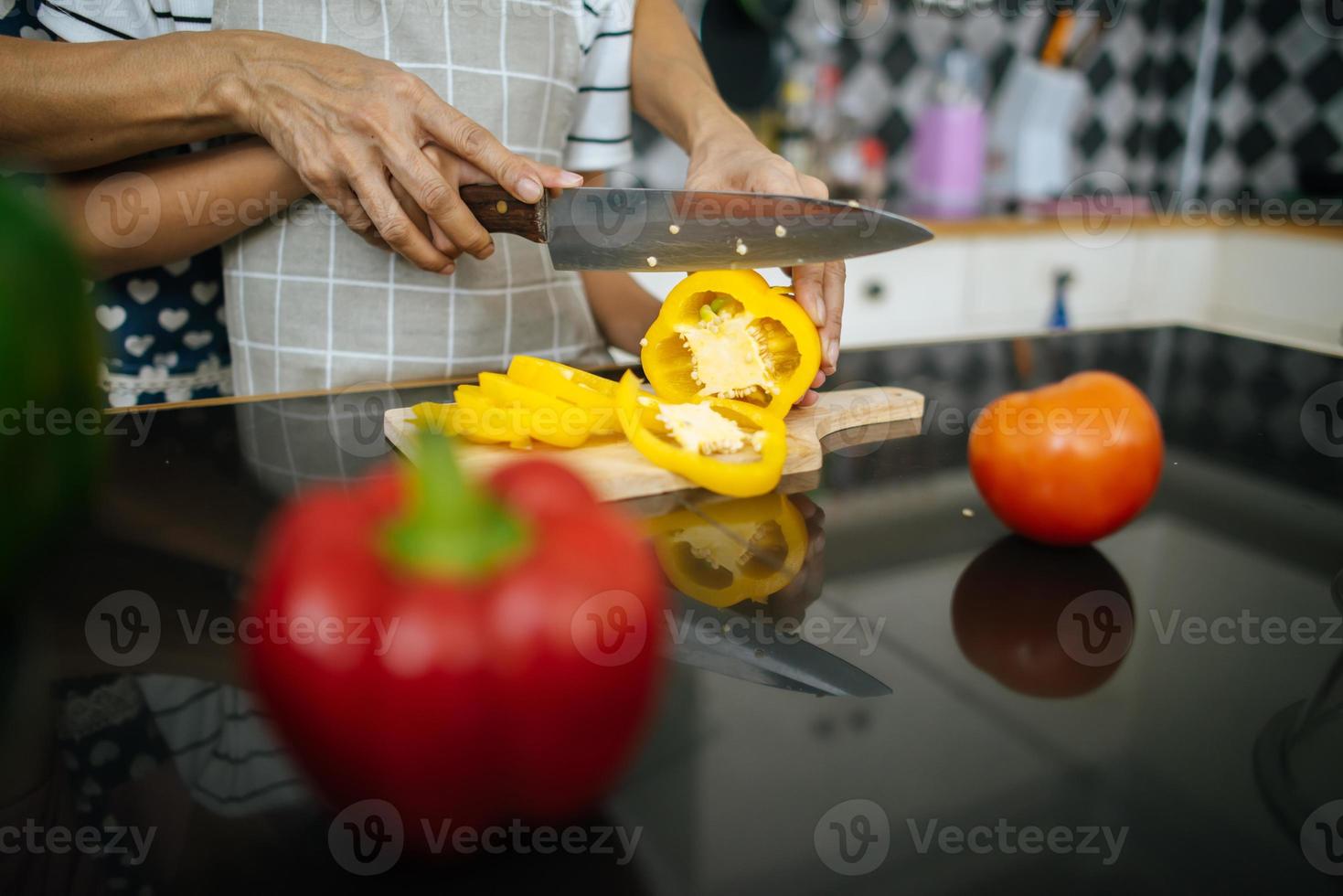 Close up of mom hand teaching her daughter preparing and chopping vegetable. Family concept. photo