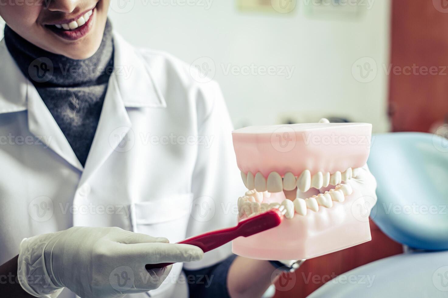 el dentista explica cómo cepillarse los dientes correctamente. foto