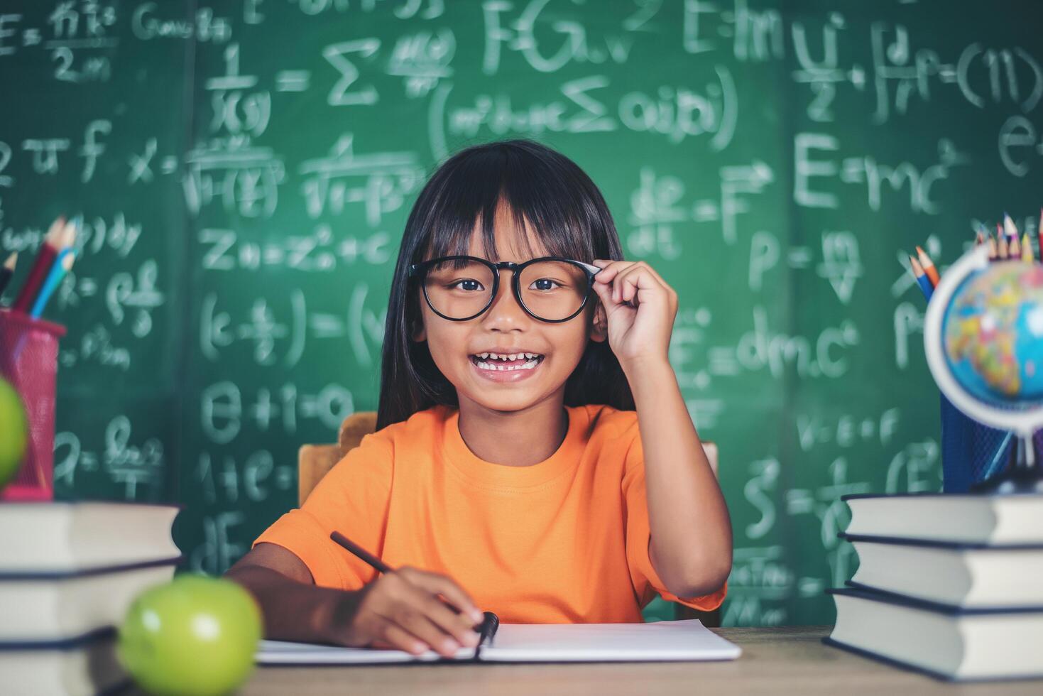 niña, con, crayón, dibujo, en, lección, en, el, aula foto