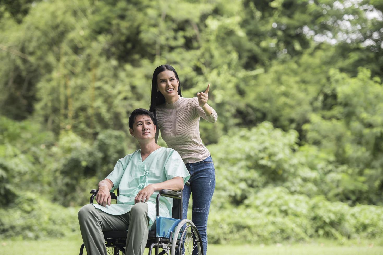 hombre discapacitado en silla de ruedas y novia en el parque foto