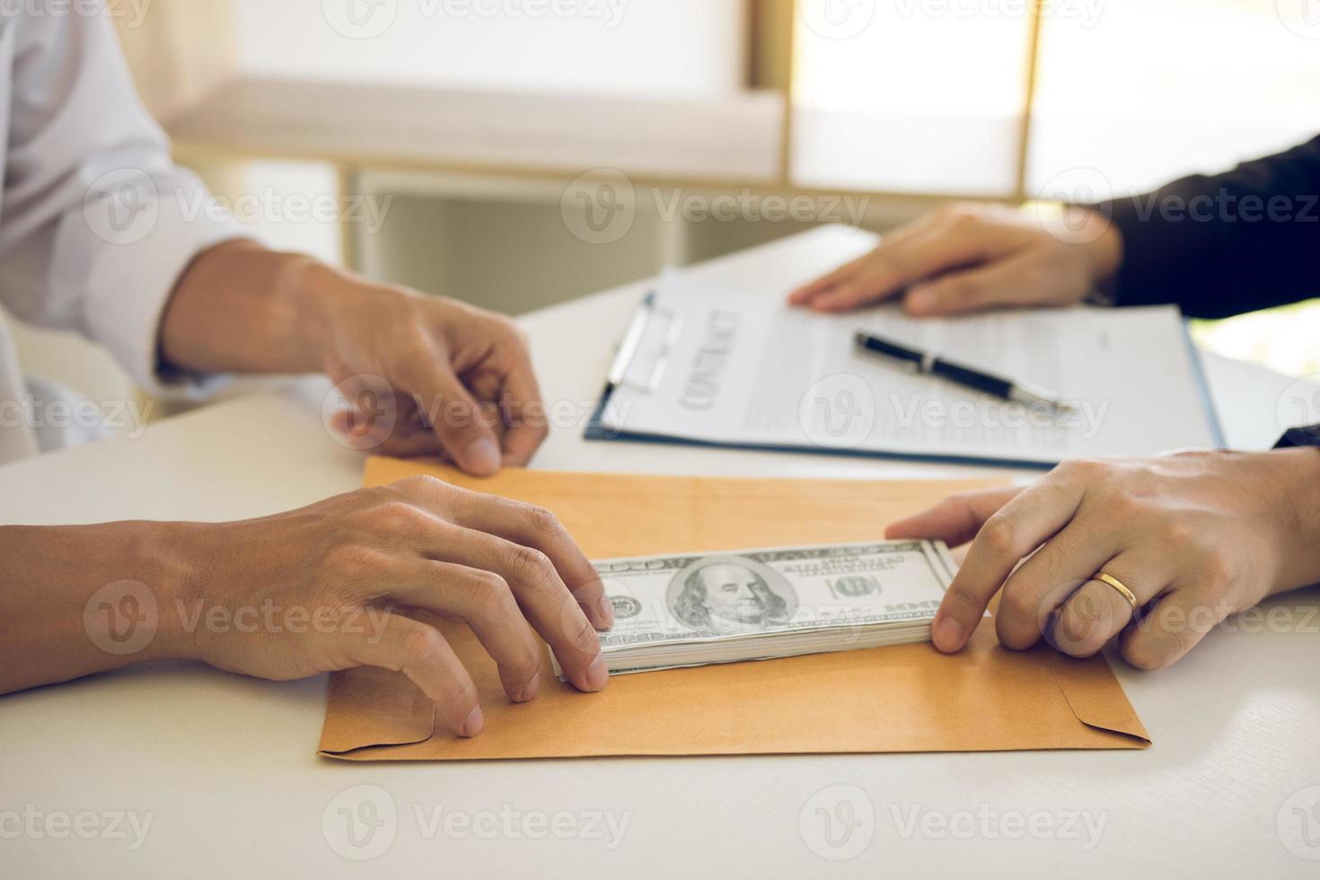 Partner has made a fraud in the contract of sale and being handed a cash and pen to the businessman signing the contract corruption bribery concept. photo
