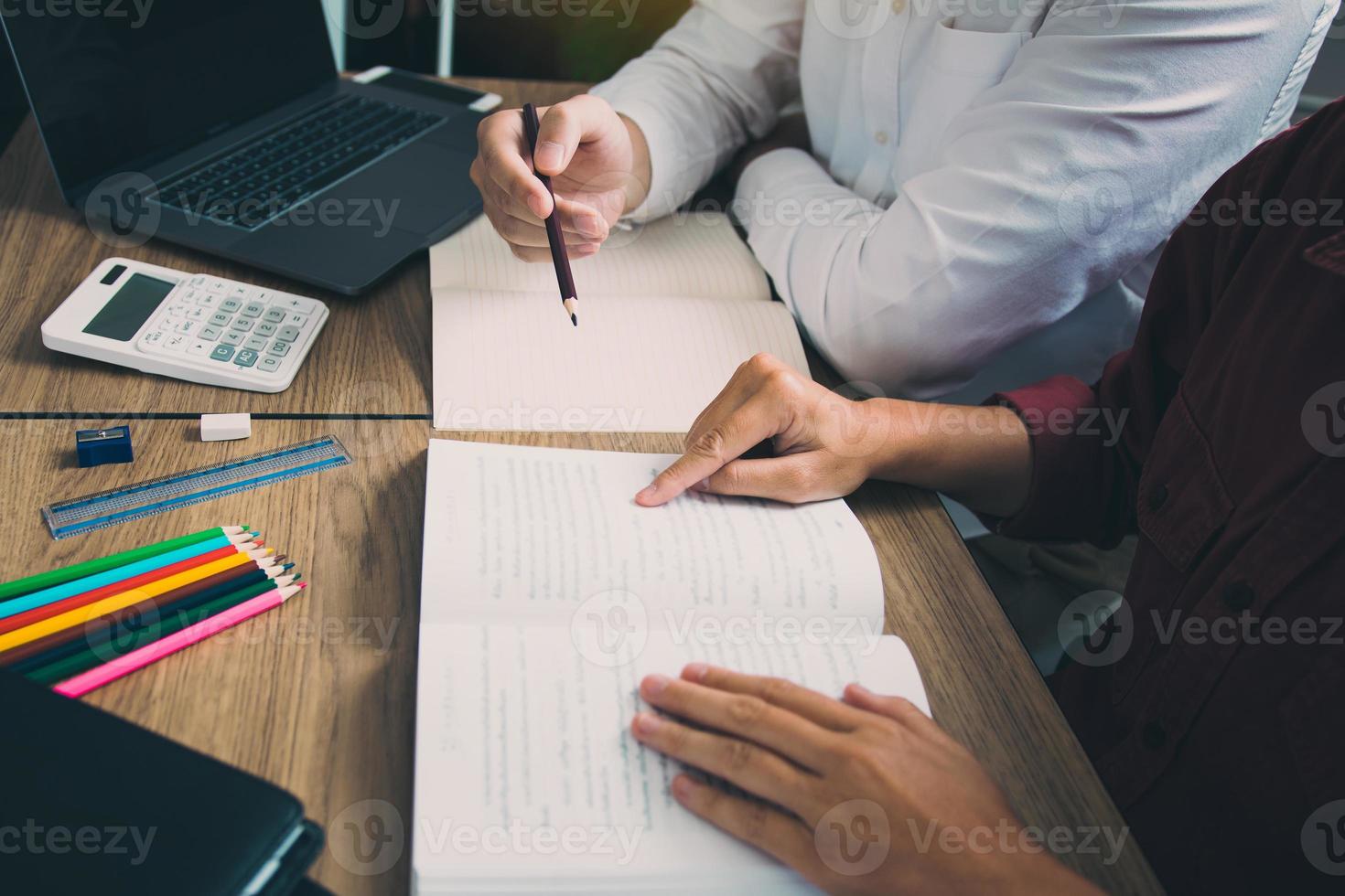 Teenager studying at desk and doing homeworks photo