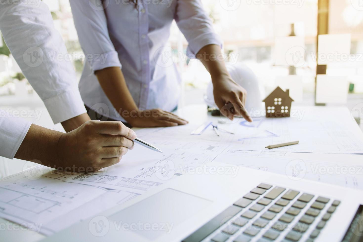 Two architect working at construction site and compass drawing pointing on blueprint with partnership. photo