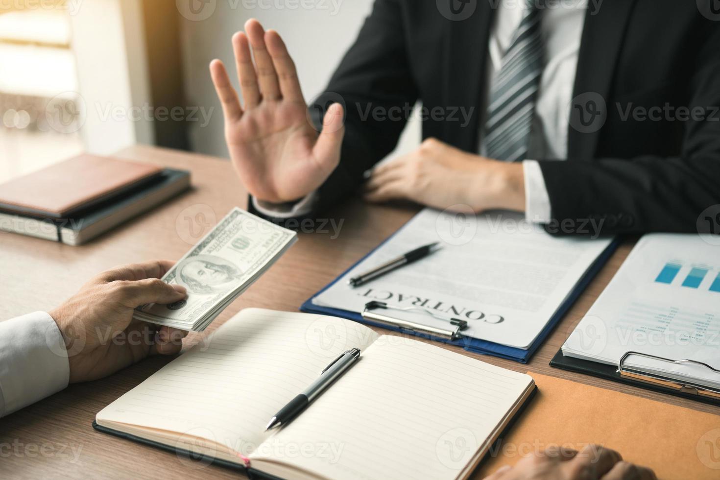 Business person refusing bribe given money by partner with anti bribery corruption concept. photo