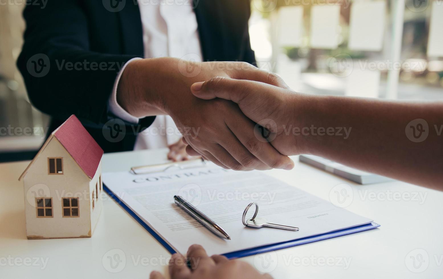 los agentes de ventas y compradores de casas trabajan para firmar nuevas casas y darse la mano. foto