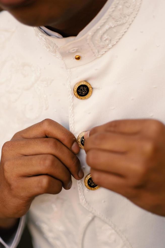 The groom tightens his cufflinks before the wedding photo