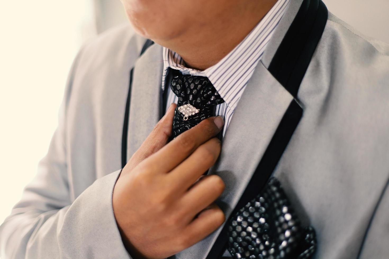 The groom tightens his cufflinks before the wedding photo