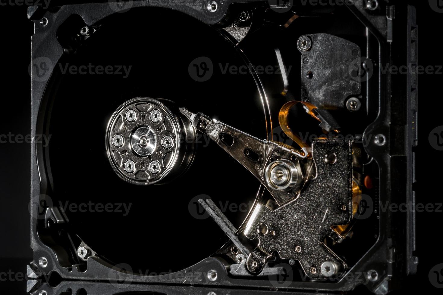 Disassembled and opened hard disk drive, inside view with reflections, isolated on black photo