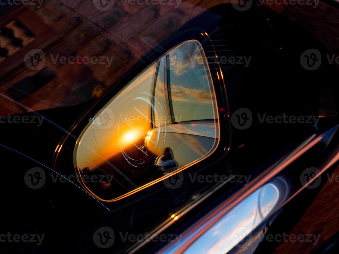 Luxury car mirror with sunset reflection photo