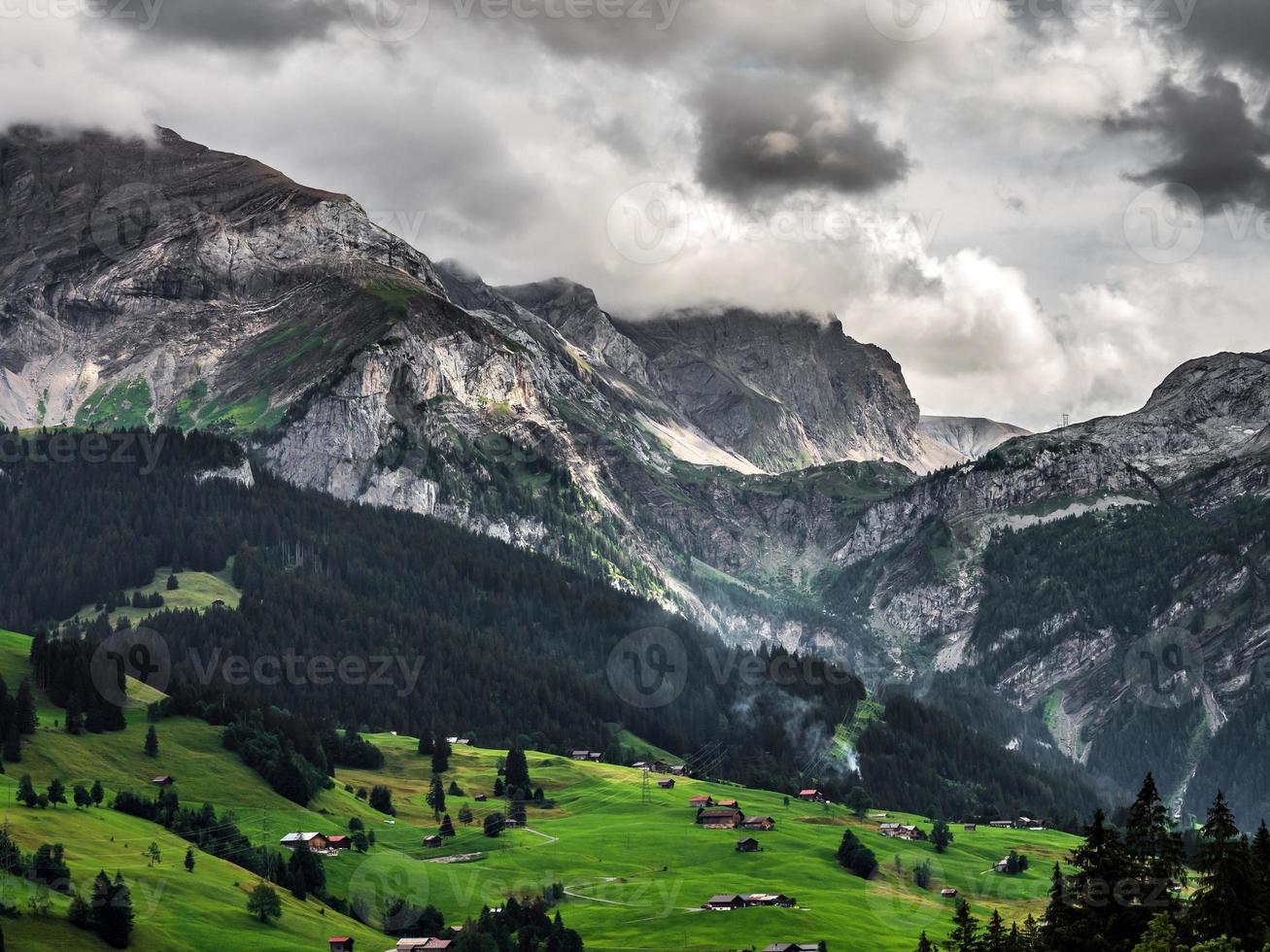Terrible lifeless rocks, a glacier in the Alps, clouds and fog spread over the peaks of the mountains photo