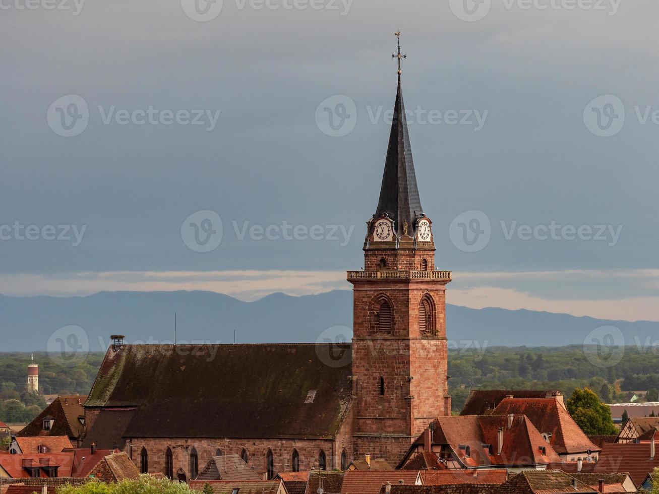 paisaje alsaciano con la aguja del campanario de un pequeño pueblo foto