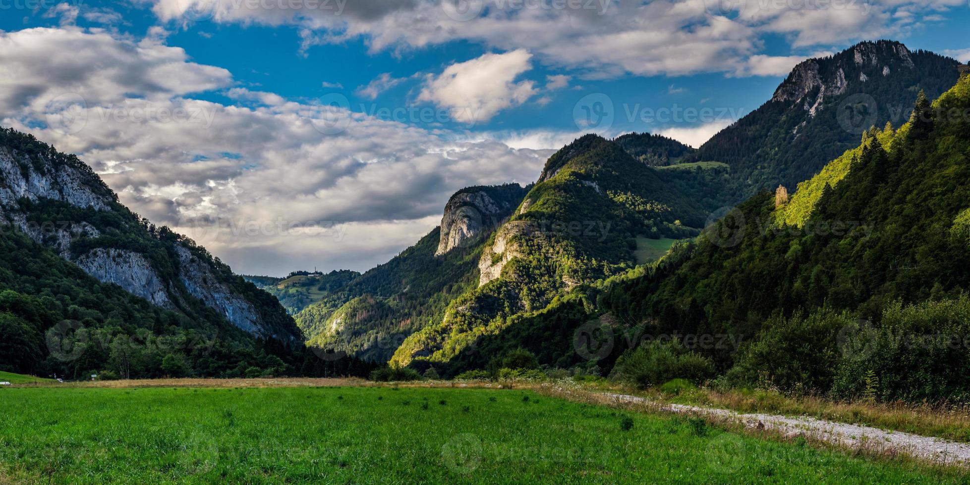 Panoramic view of alpine meadows and rocks in sunset evening lighting photo