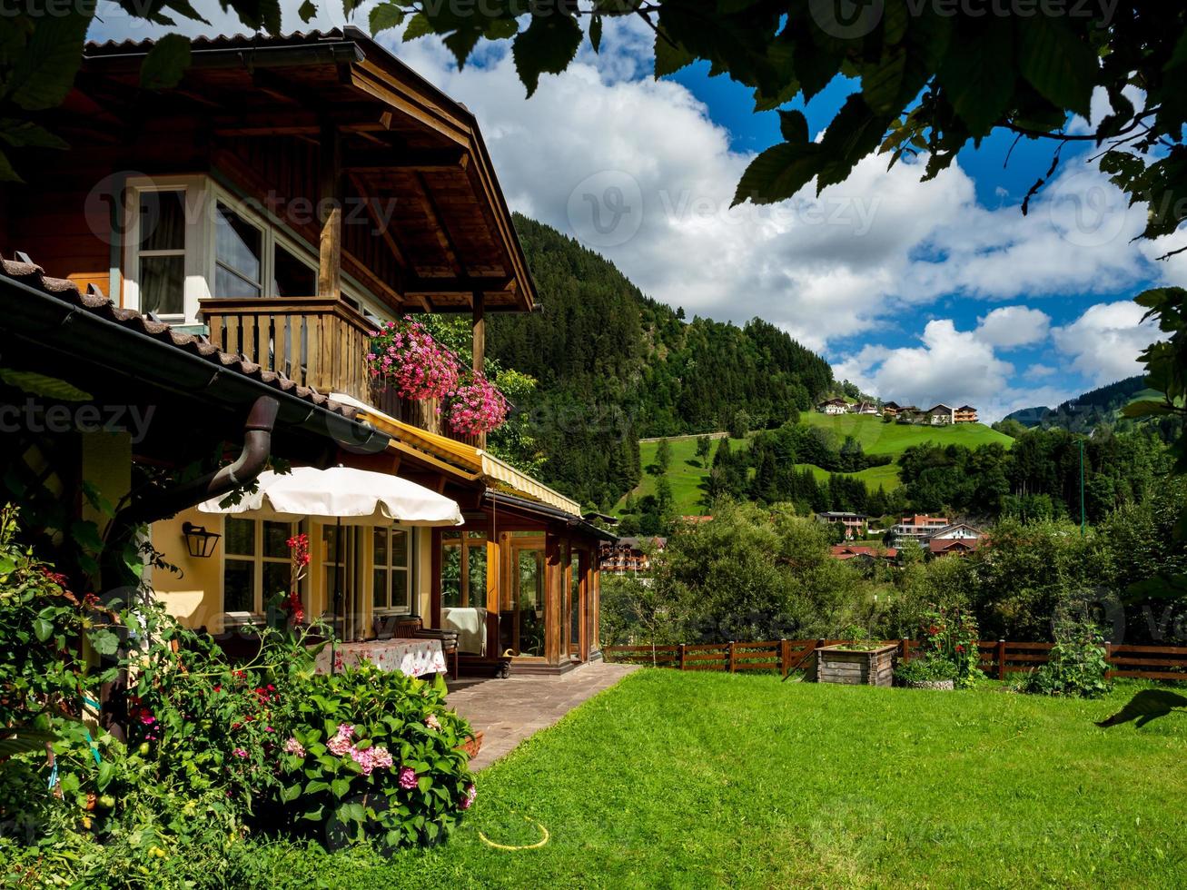 Green hills of an alpine resort in Austria in summer. Small village, hotels and chalets, all in colors. Beautiful terraces and solar panels on the roofs. The proximity of civilization and pure nature. photo