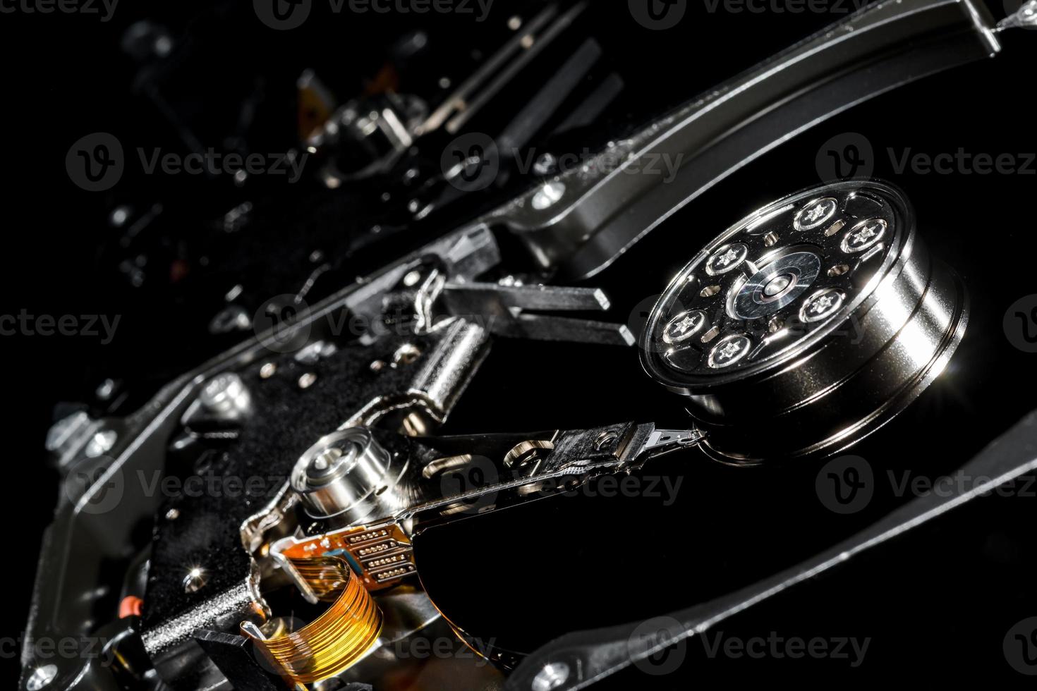 Disassembled and opened hard disk drive, inside view with reflections, isolated on black photo