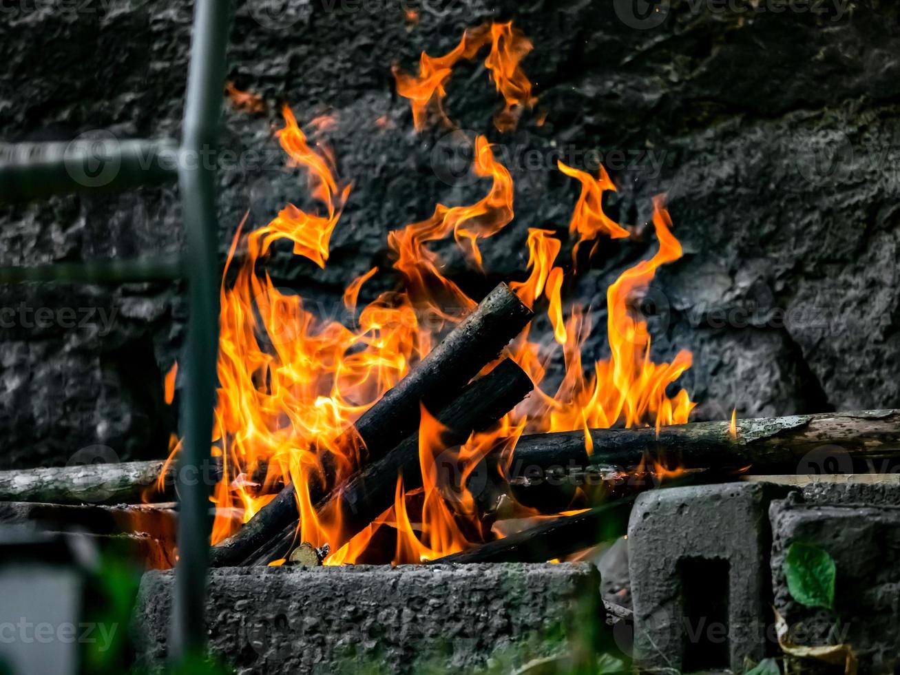 salchichas, pollo y carne se asan a la parrilla en el fuego, barbacoa en el jardín. hermosa llama. foto
