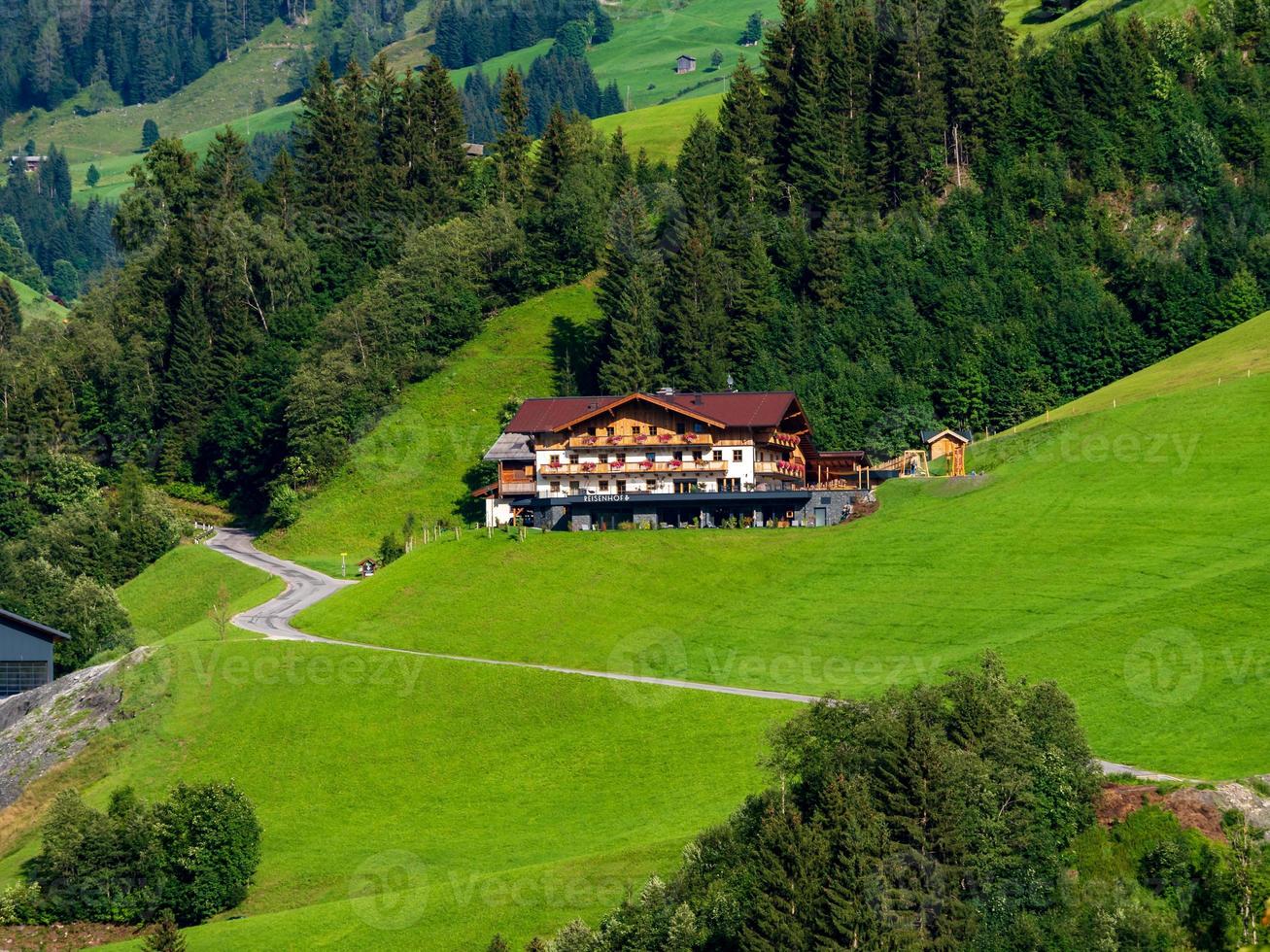 colinas verdes de un resort alpino en austria en verano. pequeño pueblo, hoteles y chalets, todo en colores. hermosas terrazas y paneles solares en los techos. la proximidad de la civilización y la naturaleza pura. foto