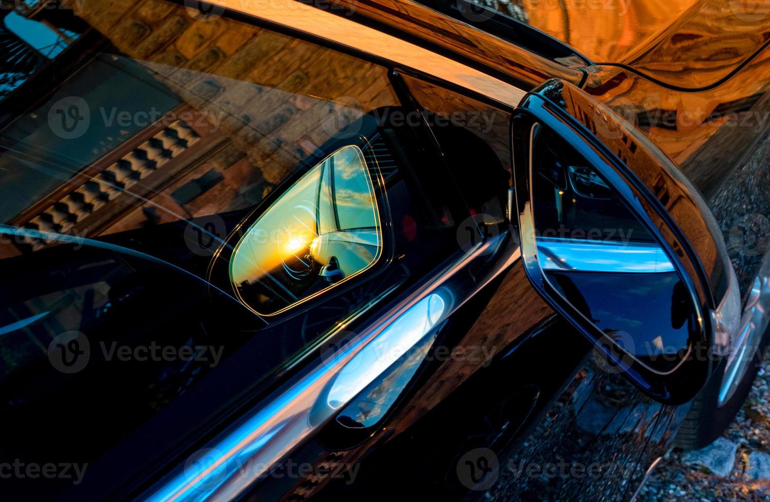 espejo de coche de lujo con reflejo de puesta de sol foto