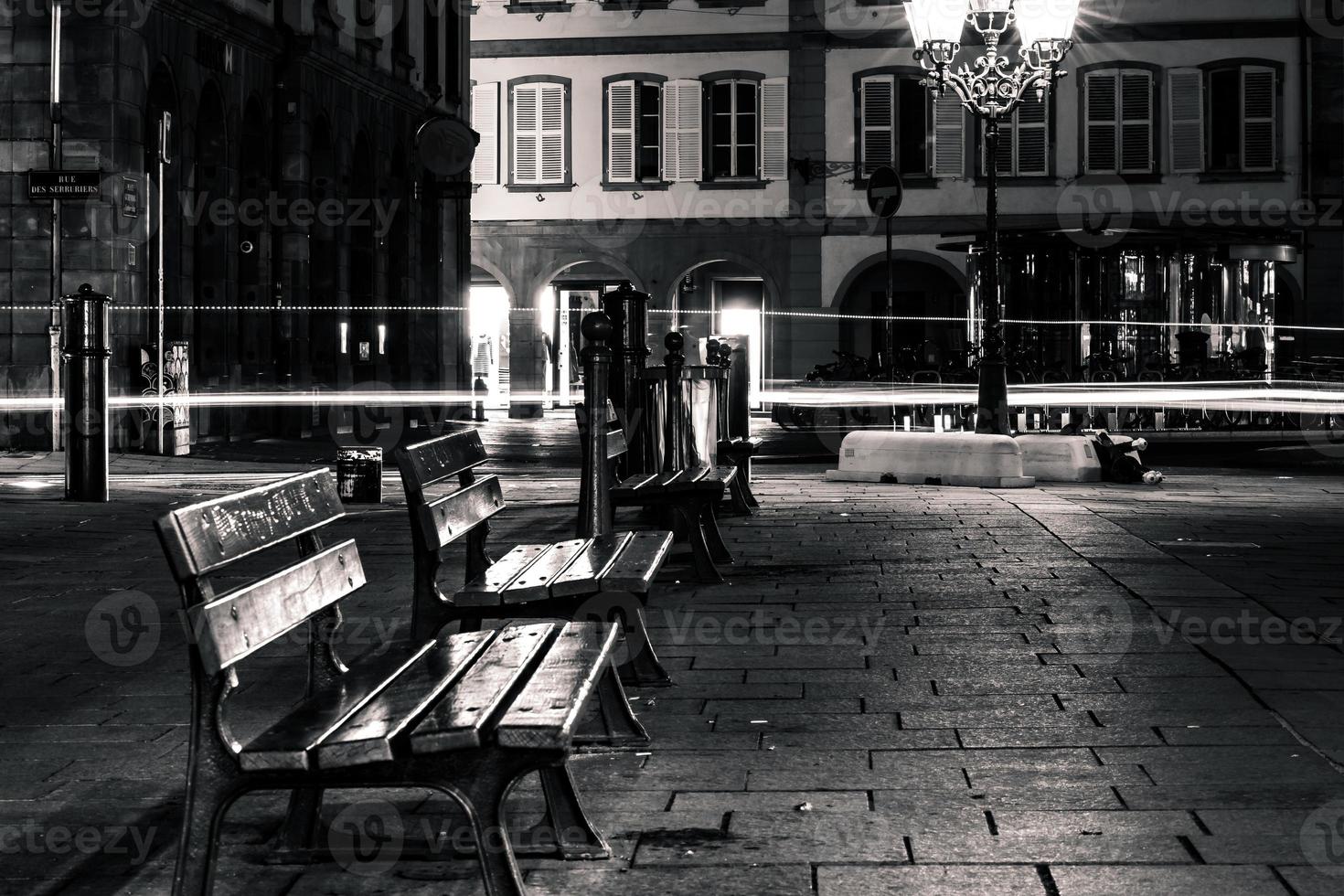 bancos vacíos solitarios en la calle nocturna en el centro de estrasburgo foto