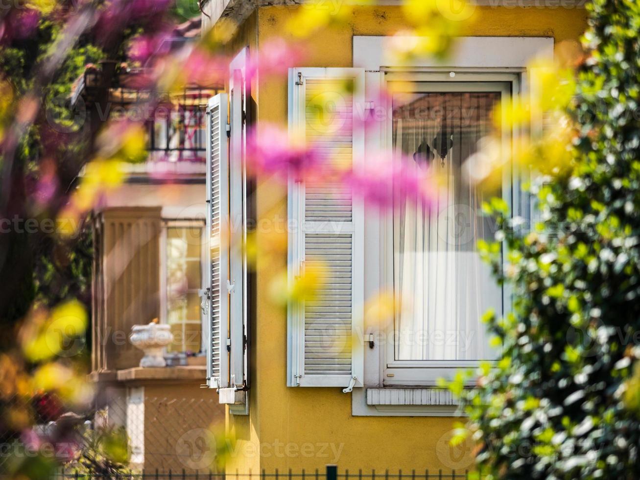 Cozy garden near the house with beautiful windows and shutters. Calmness and comfort. photo