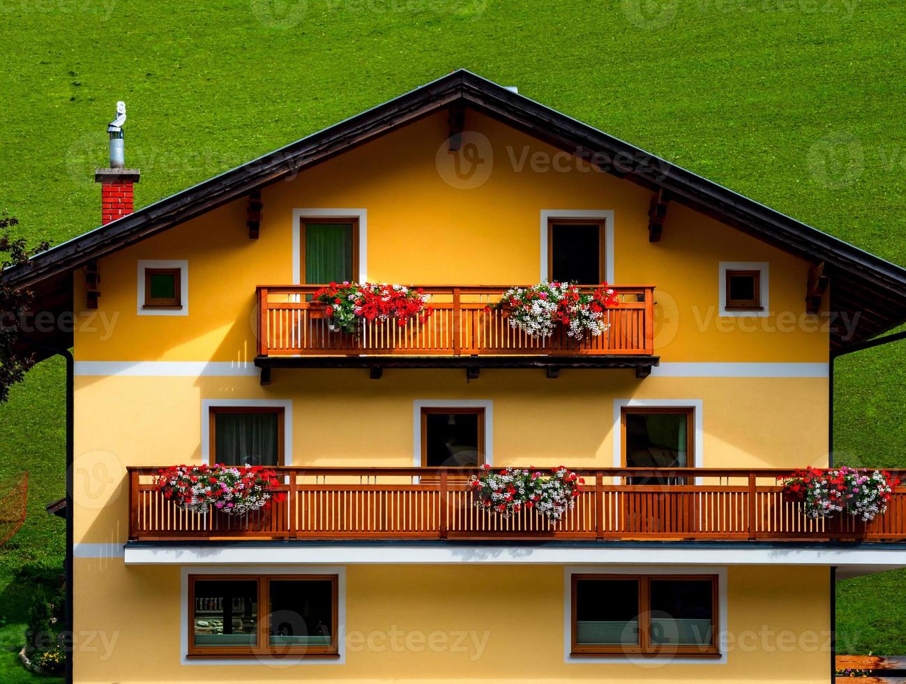 colinas verdes de un resort alpino en austria en verano. pequeño pueblo, hoteles y chalets, todo en colores. hermosas terrazas y paneles solares en los techos. la proximidad de la civilización y la naturaleza pura. foto