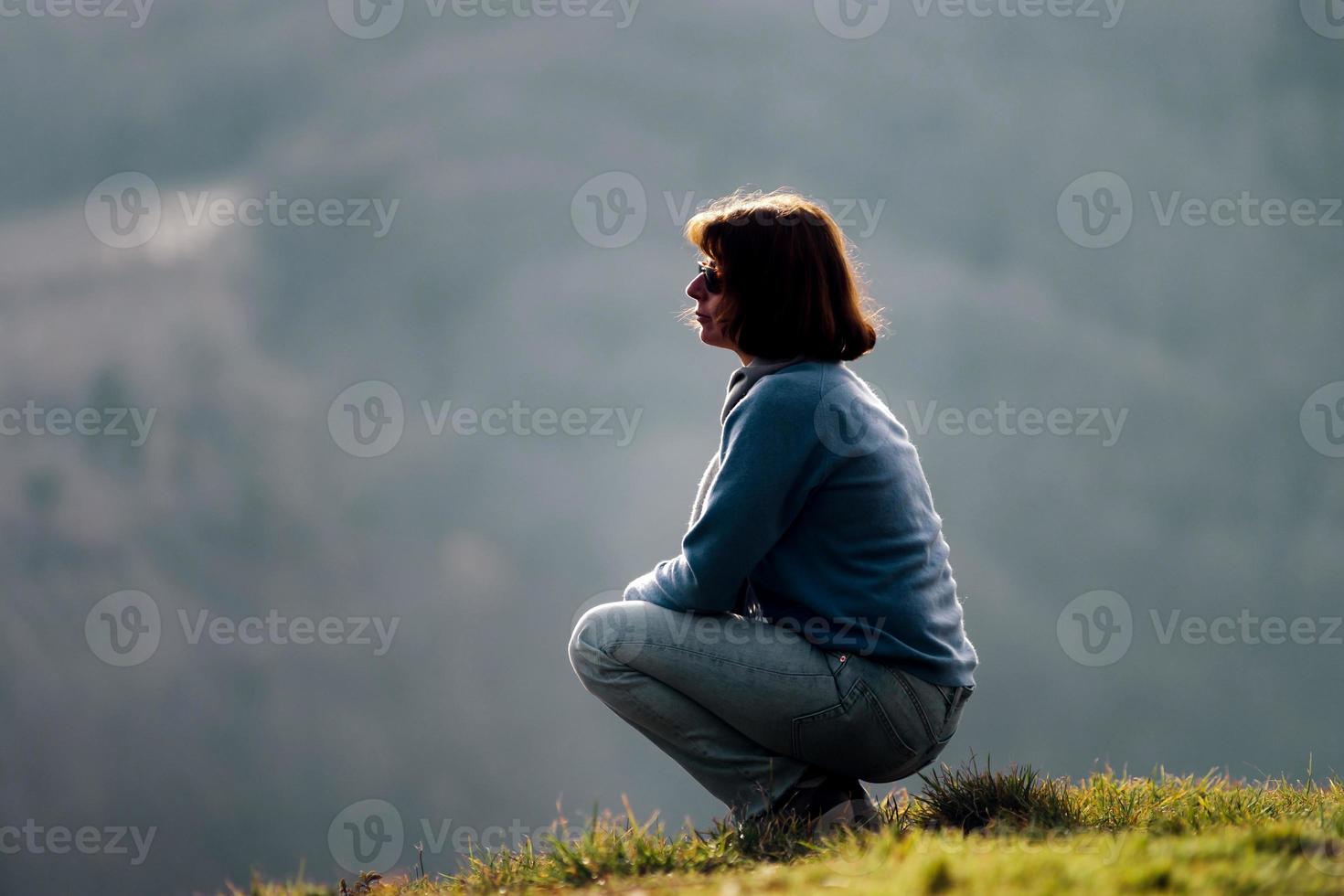 silueta de mujer. sentado en la colina. relajación y tranquilidad. foto