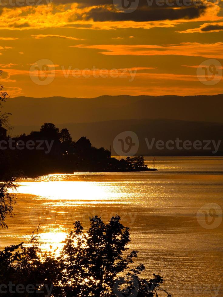 Gorgeous colors of the sunset over Lake Geneva, the reflection of the setting sun in the water, the atmosphere of peace and tranquility photo