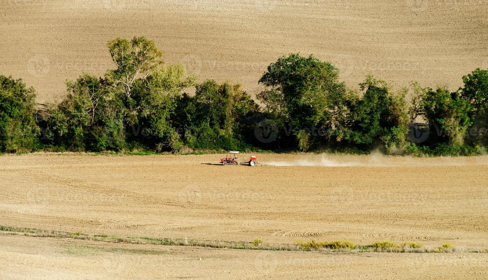 Tractor on the field, Tuscany, autumnal plowing, agricultural concept photo