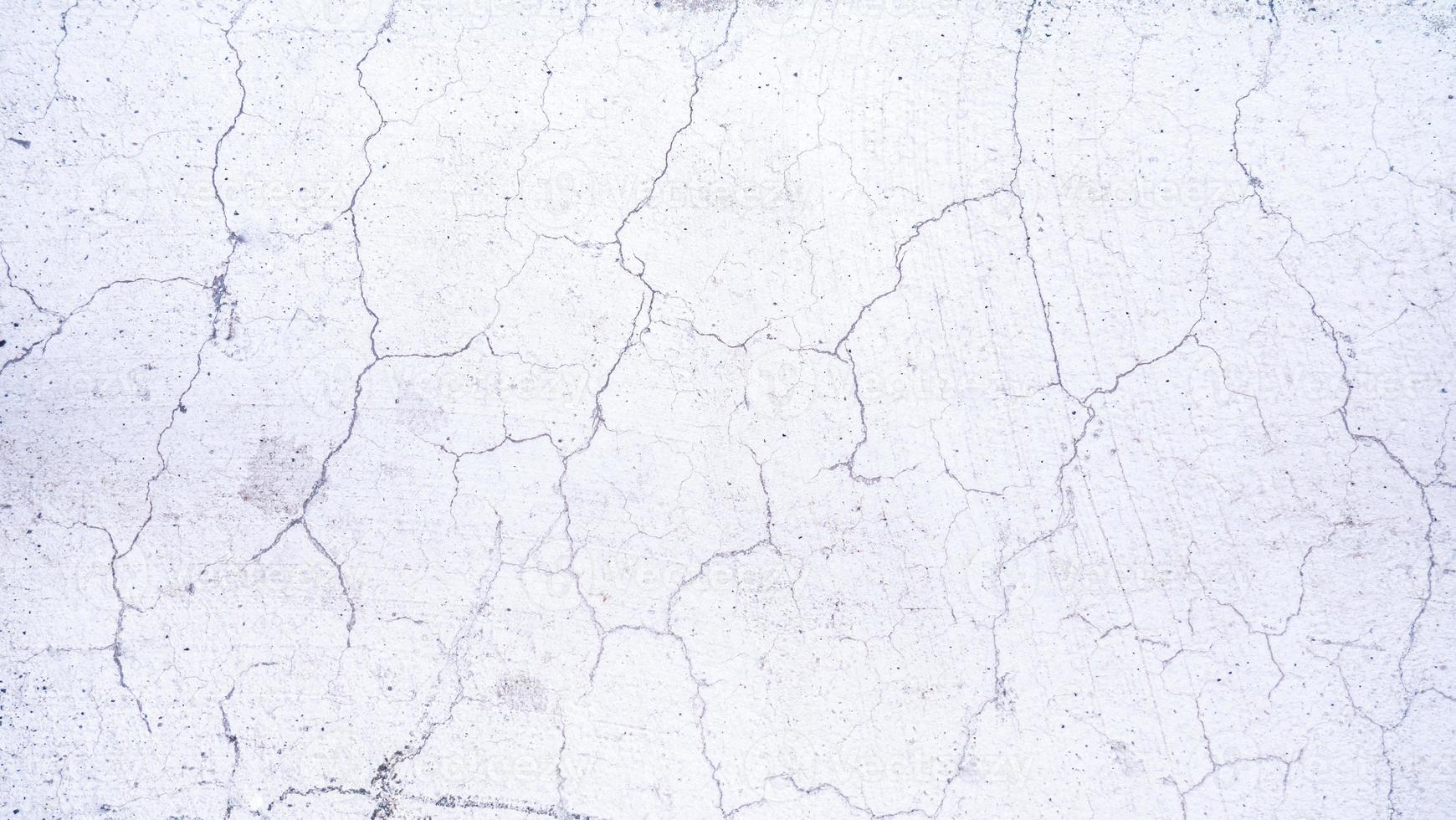 Cracks on the surface of the plaster wall or white plaster wall. Rough surfaces with cracks. photo