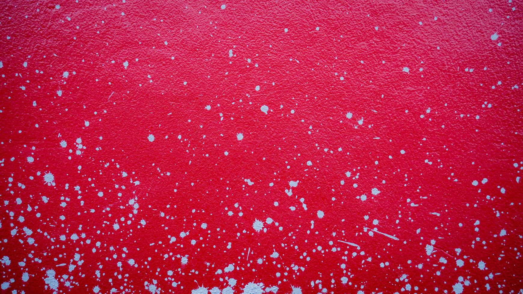 Red cement wall with splash marks, scattered mortar, used as a background or wallpaper. photo
