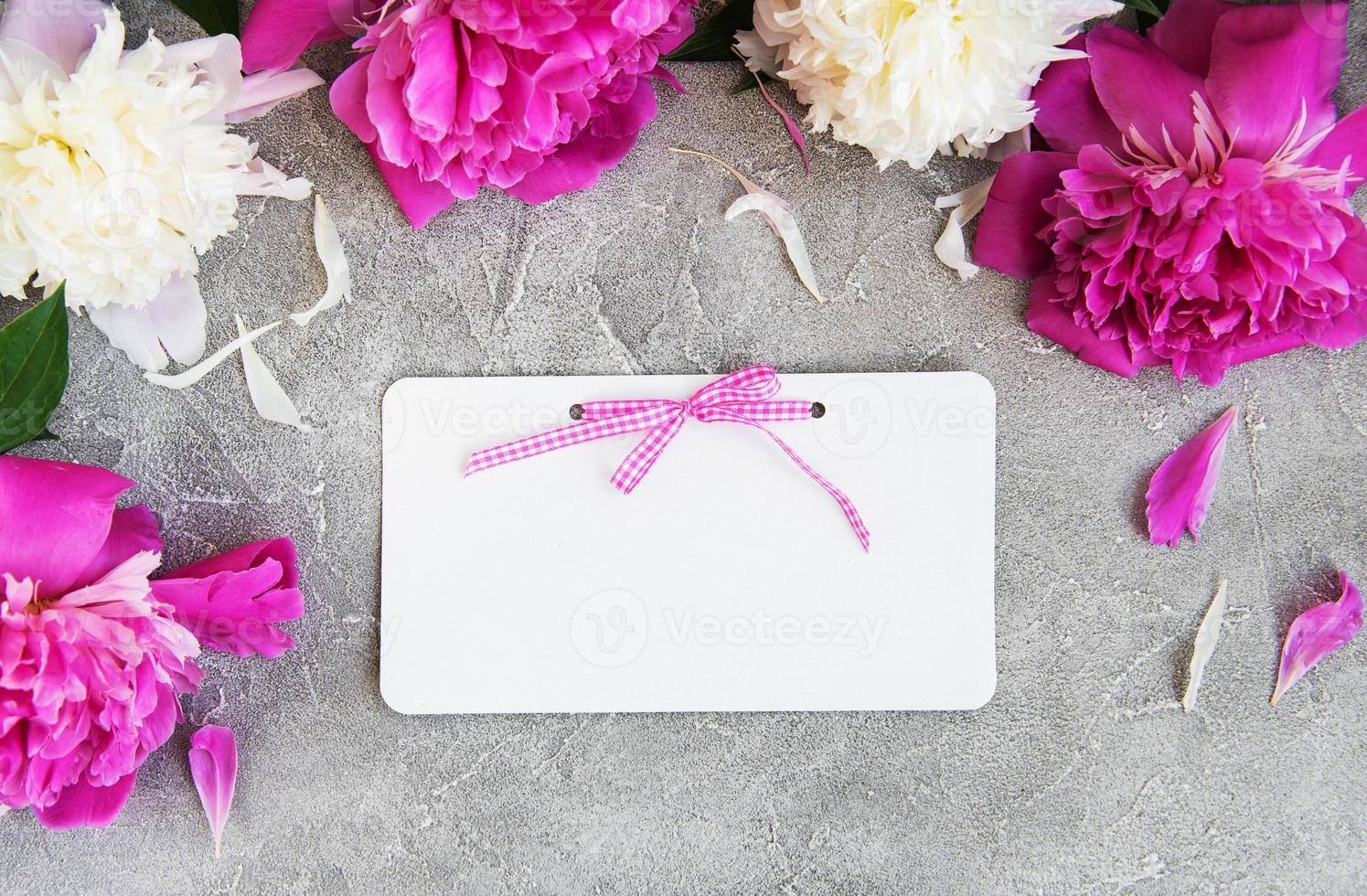 invitation card and pink peony flowers photo