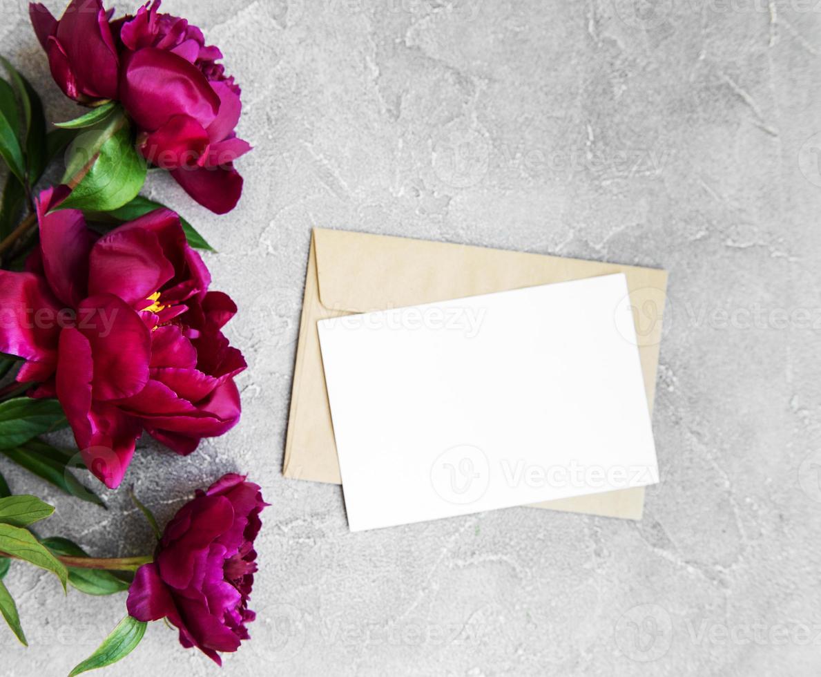 tarjeta de invitación, sobre artesanal y flores de peonía rosa foto