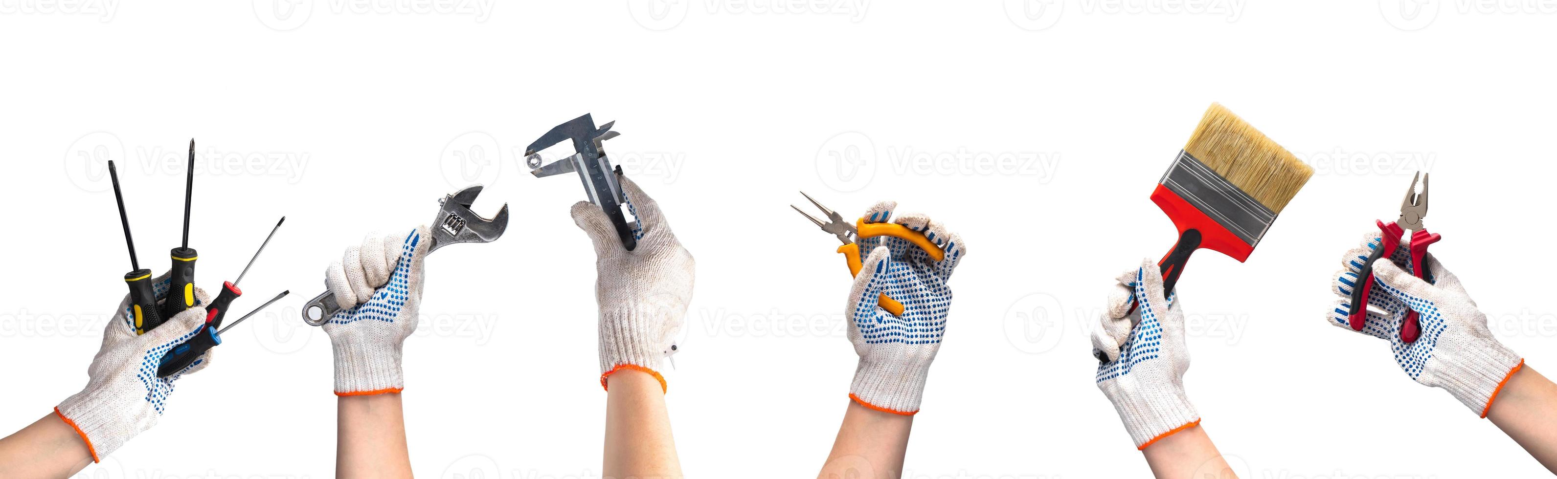 Hands in work gloves hold repair tools. photo
