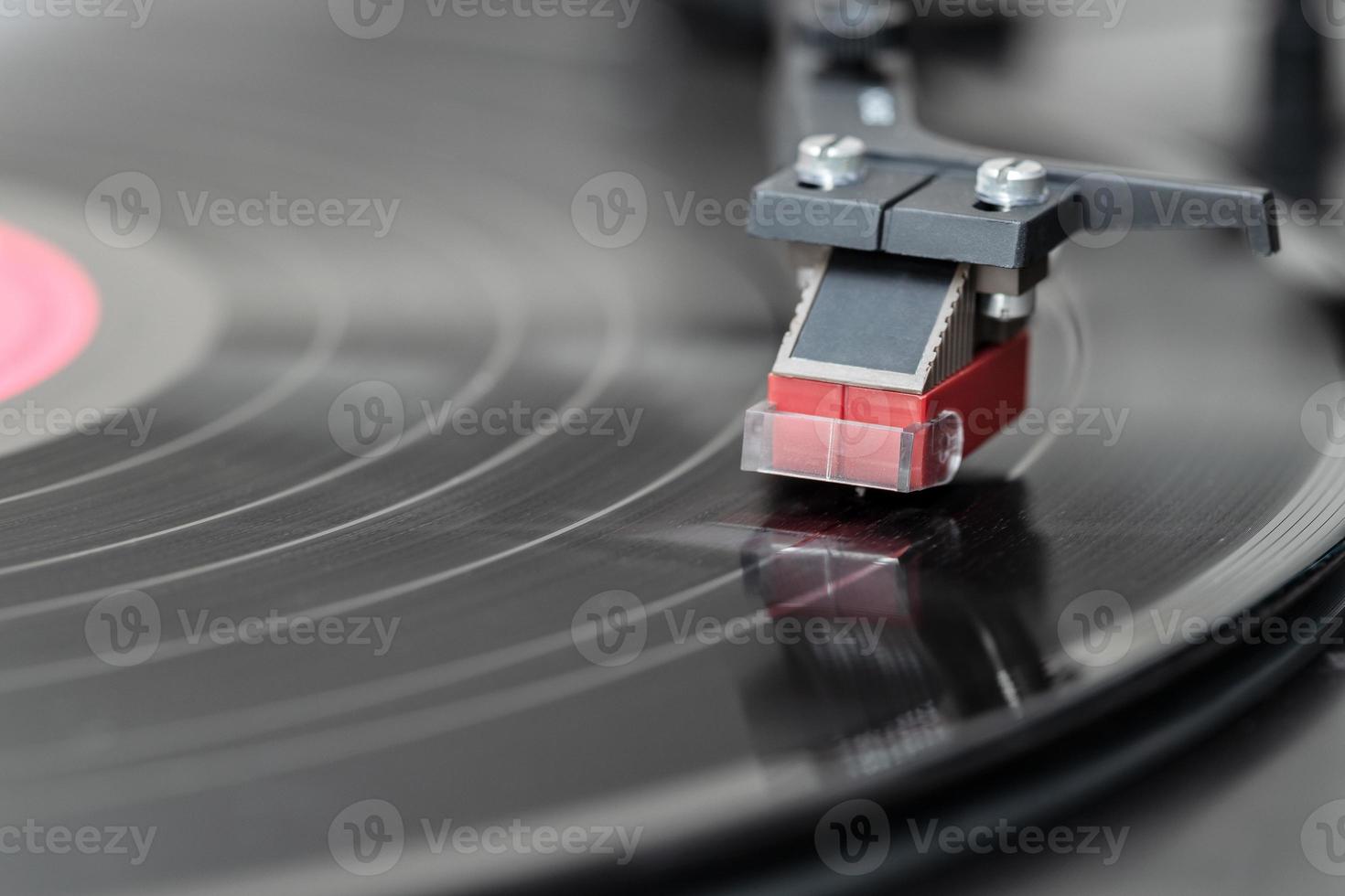 Closeup of vintage record player while playing a vinyl record. Black platter photo