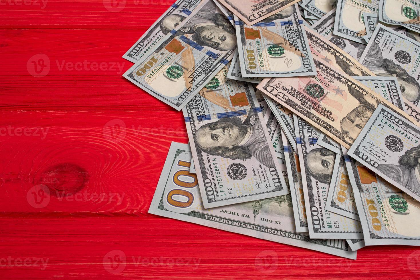 dinero y concepto financiero. notas de papel dólares sobre un fondo de madera roja. foto