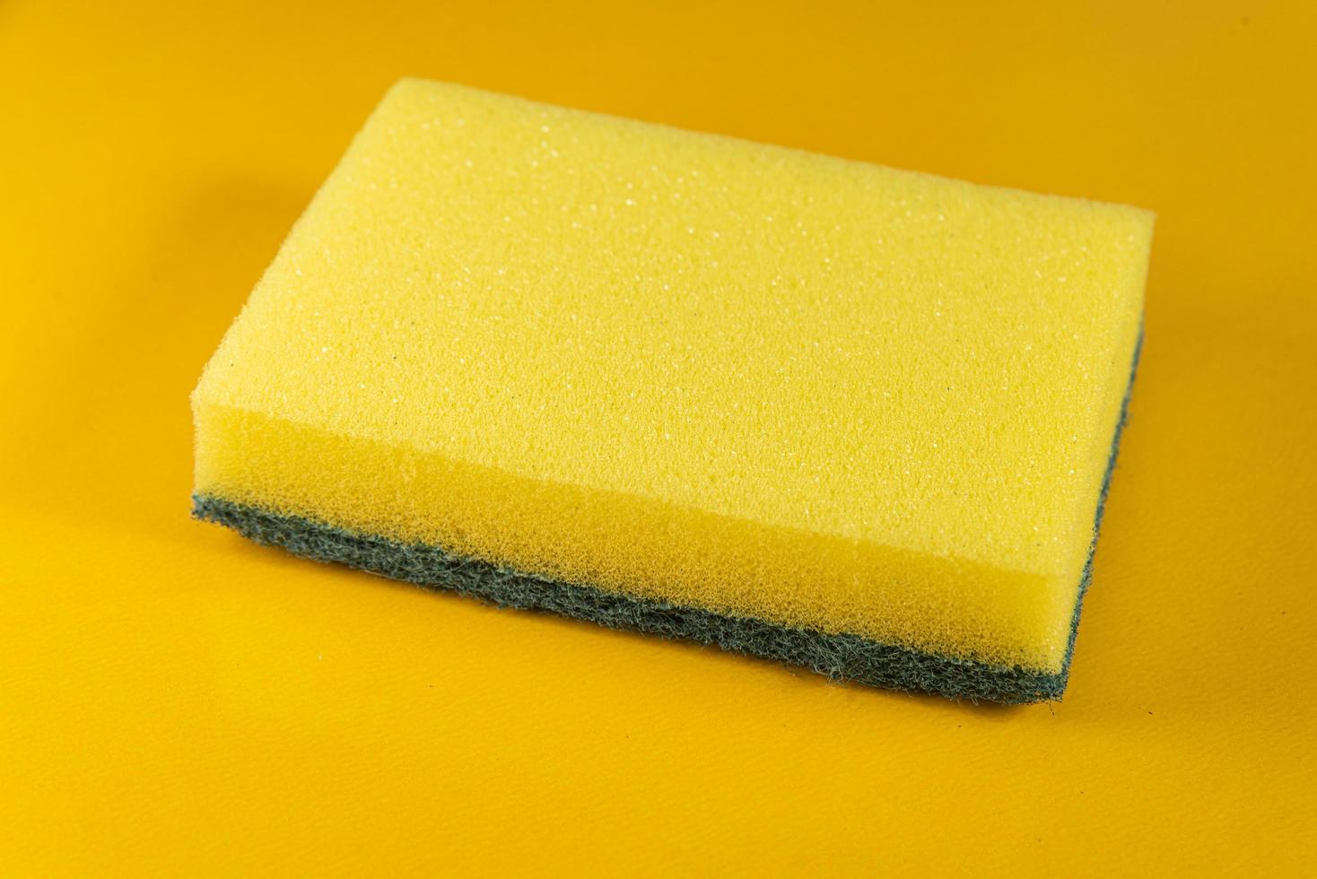 Kitchen sponge on the yellow background photo