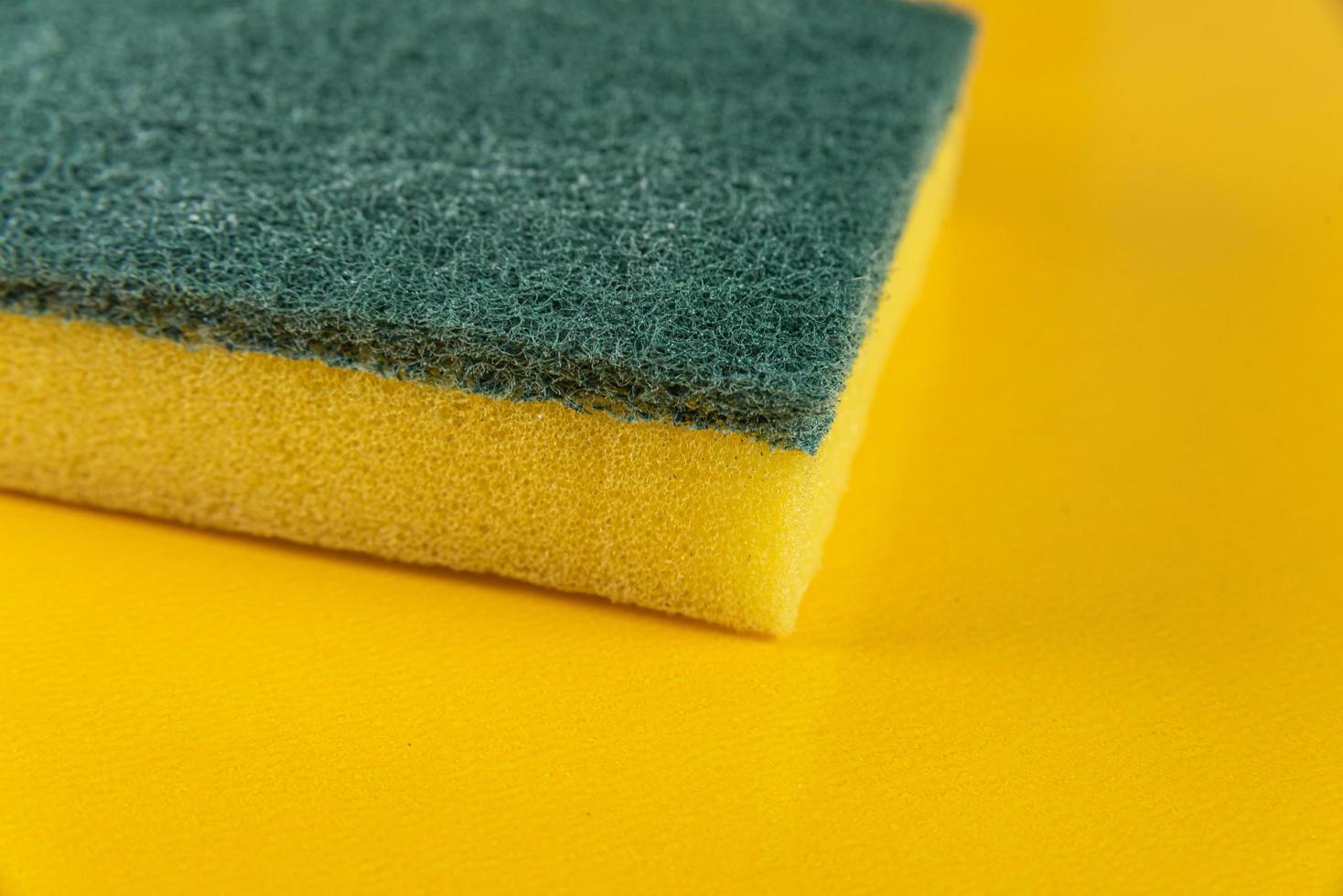 Kitchen sponge on the yellow background photo
