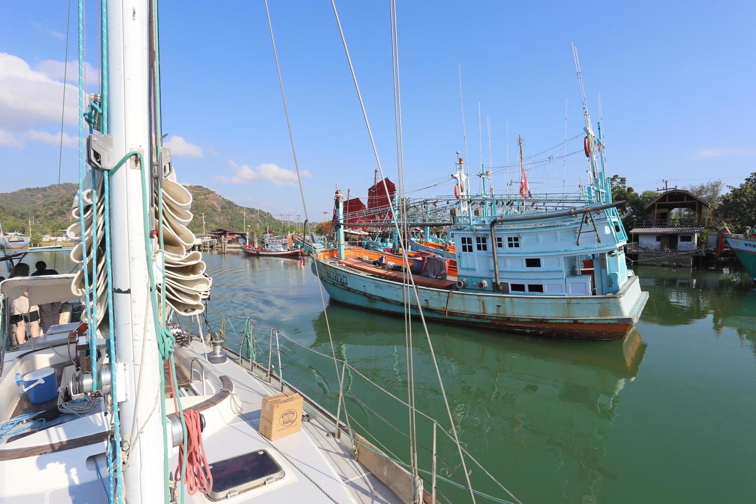 Pranburi, Prachuap Khiri Khan, Thailand 2022 A fishing boat passed by a sailboat photo