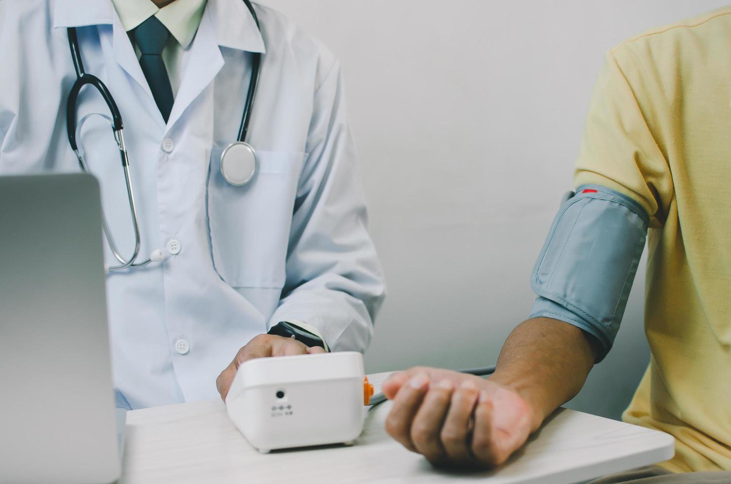 doctor measures the blood pressure of an elderly male patient. photo