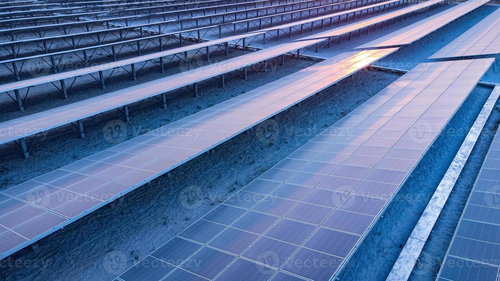 vista superior de los paneles solares celda solar en la granja solar y la iluminación solar se refleja con espacio de copia. campo de la planta de energía fotovoltaica para la generación de energía. concepto de calentamiento global y cambio climático. foto