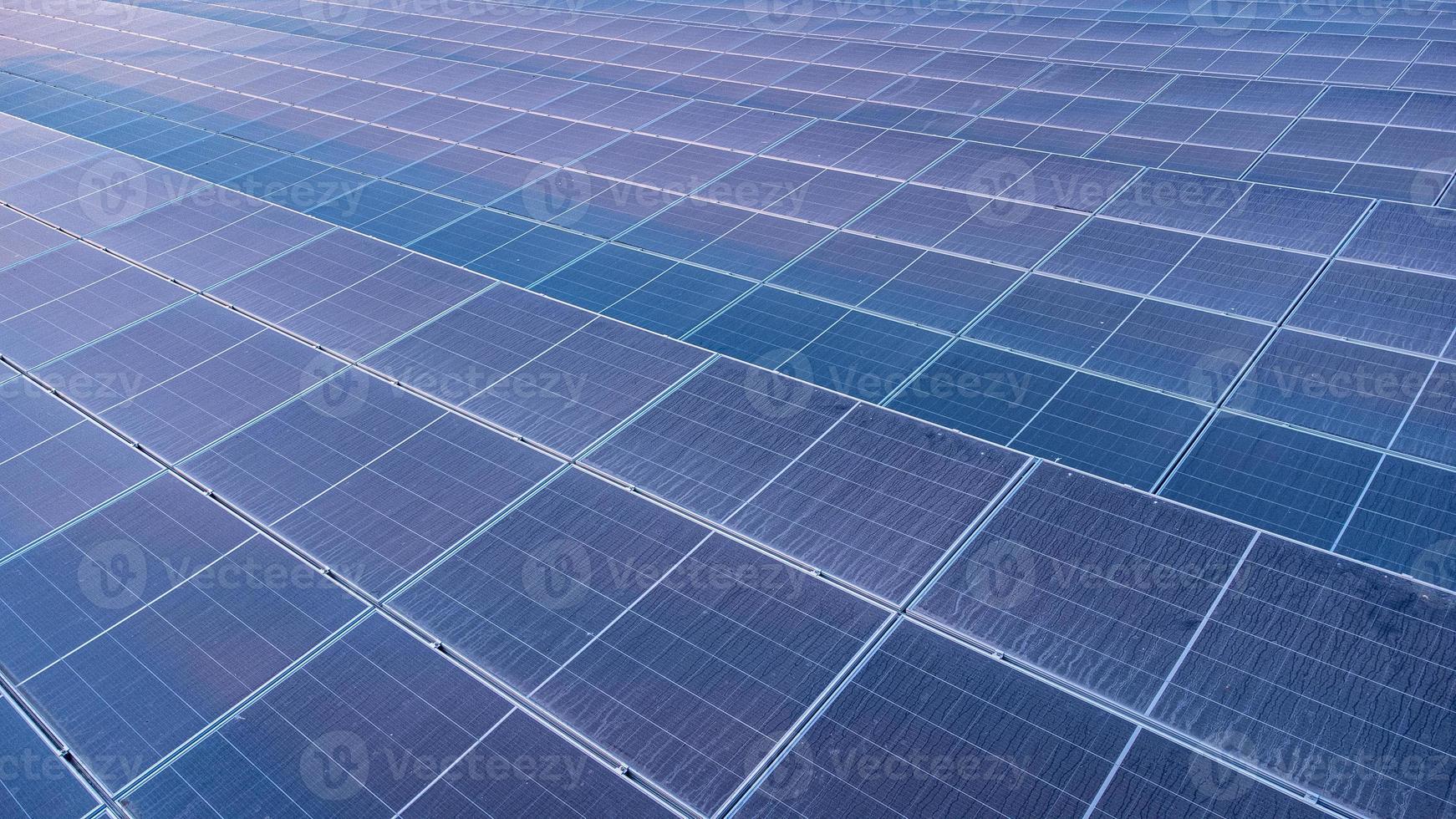 vista superior de los paneles solares celda solar en la granja solar y la iluminación solar se refleja con espacio de copia. campo de la planta de energía fotovoltaica para la generación de energía. concepto de calentamiento global y cambio climático. foto