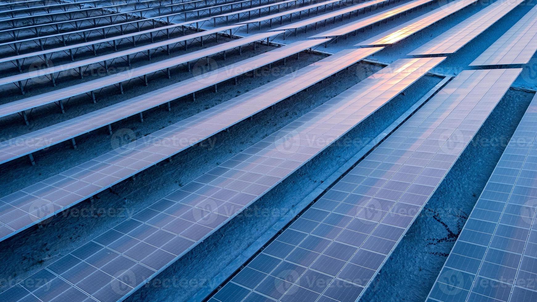 vista superior de los paneles solares celda solar en la granja solar y la iluminación solar se refleja con espacio de copia. campo de la planta de energía fotovoltaica para la generación de energía. concepto de calentamiento global y cambio climático. foto