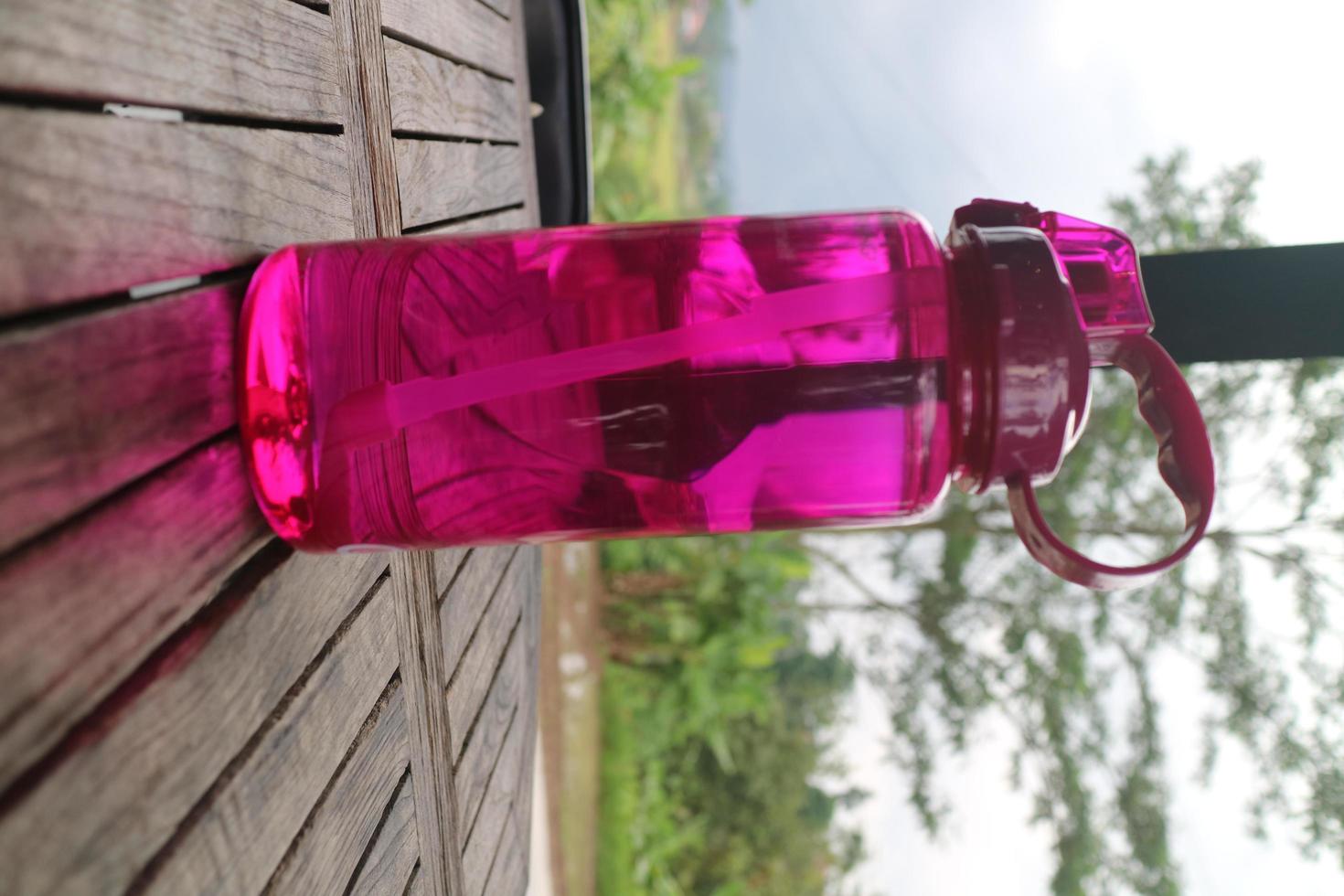 big purple bottle on the wooden table photo