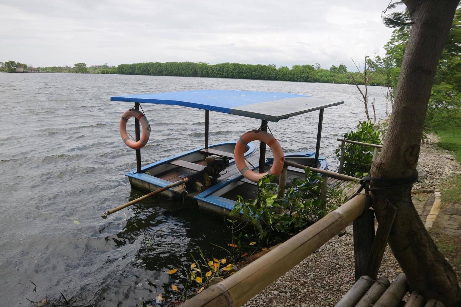 wooden boat with engine on the edge of the swamp photo