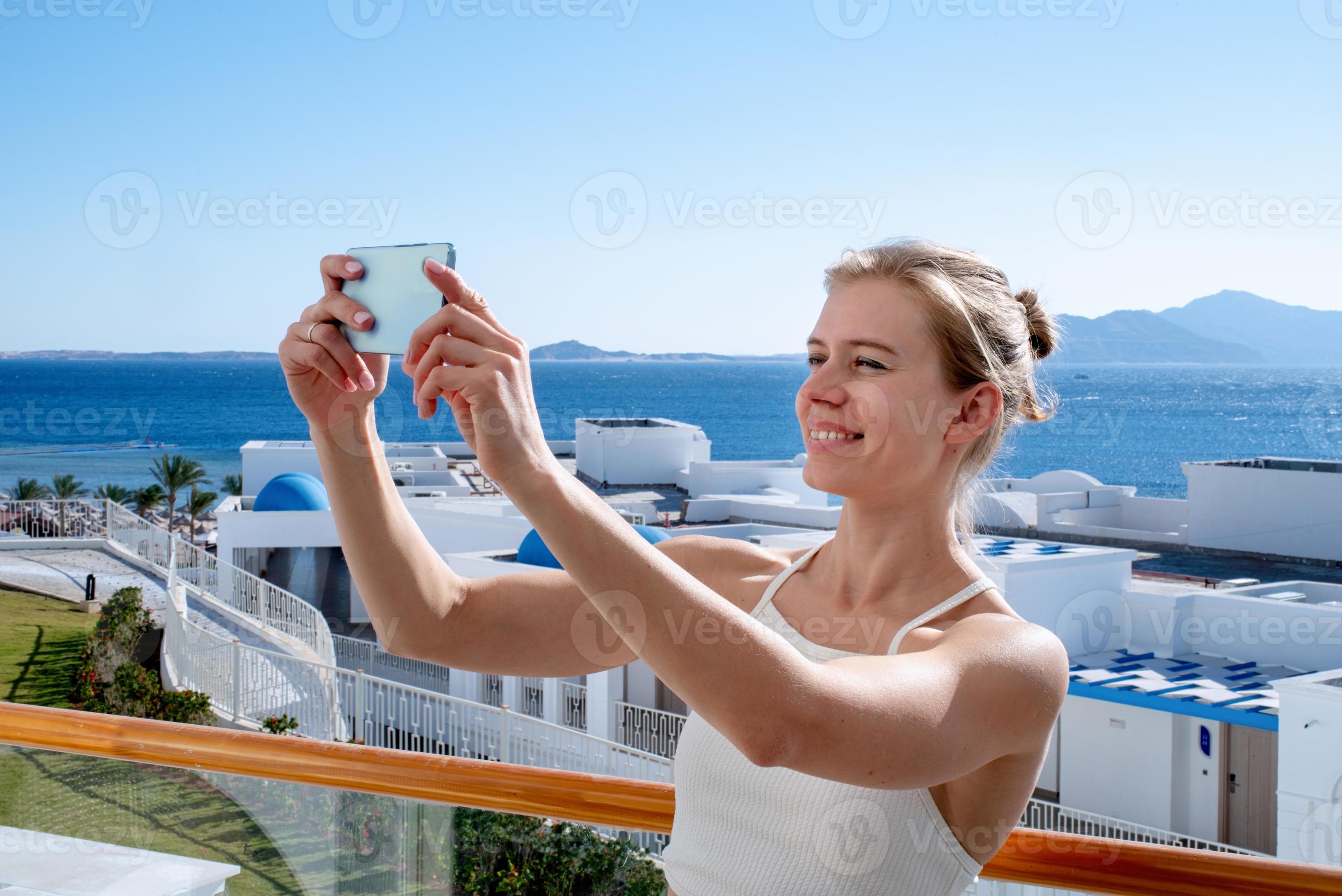 Happy woman in swimsuit taking selfie