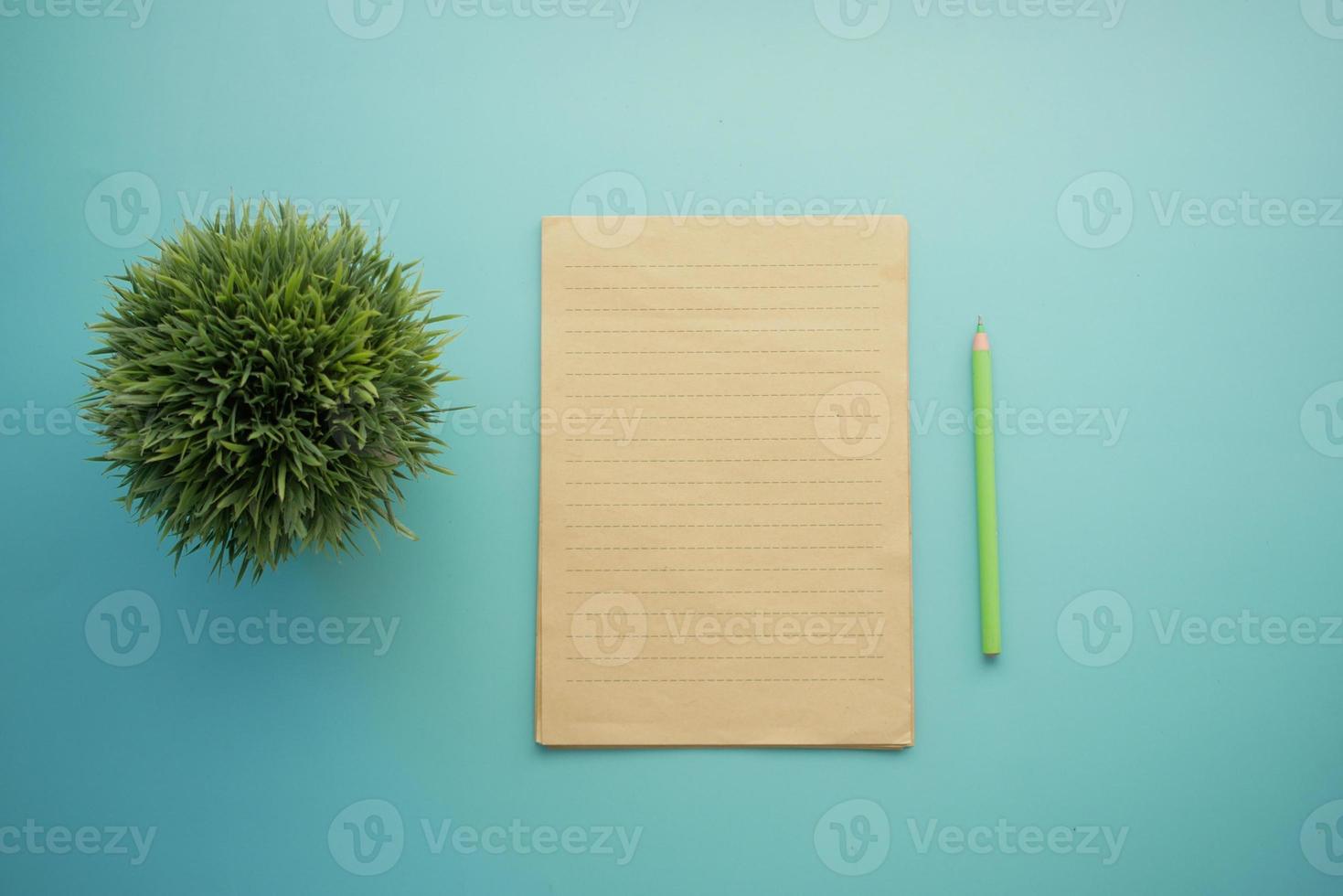 top view of blank paper and pencil on light green background photo